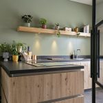 Keuken met houtmotief, groene muur en antraciet werkblad
